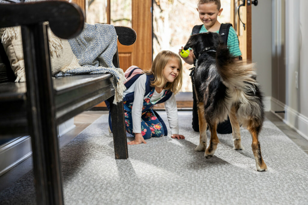 Kids plying with dog on carpet flooring | McCools Flooring